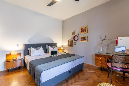 a bedroom with a bed and a desk with a laptop on it at Apartments LOTA with heated pool on top location in Supetar