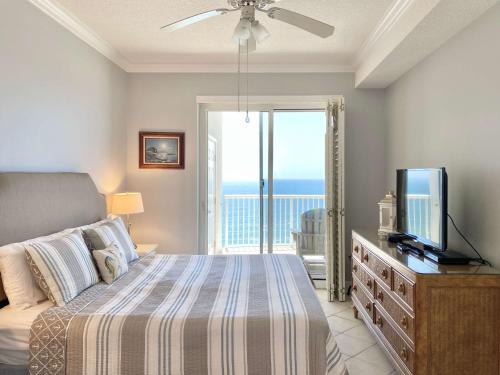 a bedroom with a bed with a television and a balcony at Island Royale P103 by ALBVR - Beachfront Penthouse living at its best - Gorgeous views in Gulf Shores