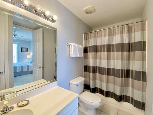 La salle de bains est pourvue de toilettes, d'un lavabo et d'un miroir. dans l'établissement Island Royale P103 by ALBVR - Beachfront Penthouse living at its best - Gorgeous views, à Gulf Shores