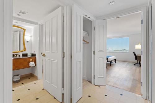 a hallway with white doors and a room with a table at Sleep SIX 1BR 2BA CozySuites on the Boardwalk in Atlantic City