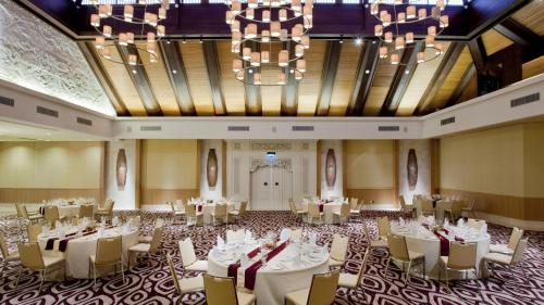 a banquet hall with tables and chairs and a chandelier at Holiday Inn Express Baruna by IHG in Kuta