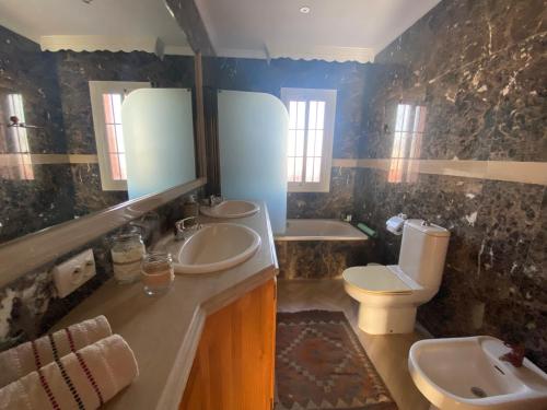 a bathroom with two sinks and a toilet at Casa Delfina in Estepona