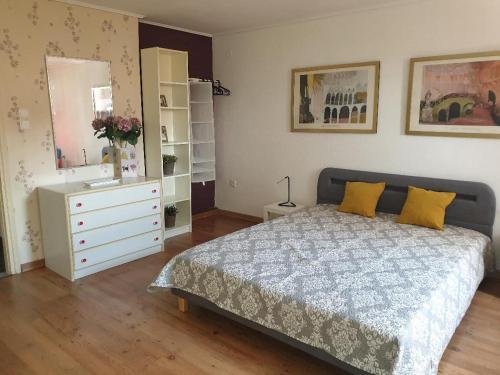a bedroom with a bed and a dresser and a mirror at Euphoria beach house in Paleo Tsifliki