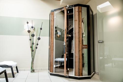 a glass shower in a room with a table at Hotel Gruber in Sesto