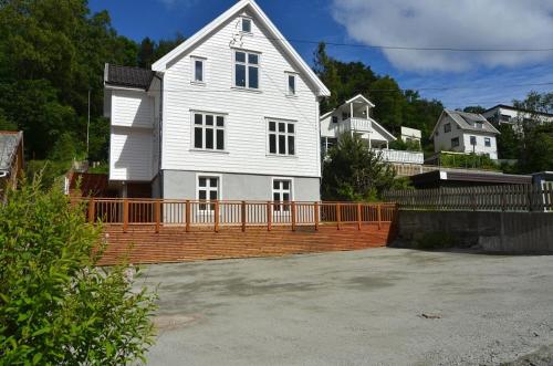 a large white house with an orange fence at Modern apartment 7 min to center in Bergen