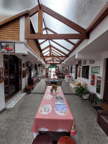 a living room with a table with a red table cloth at Pousada dos Marins in Campos do Jordão