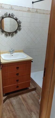 a bathroom with a sink and a mirror and a tub at Casa do Loureiro in Ferrarias