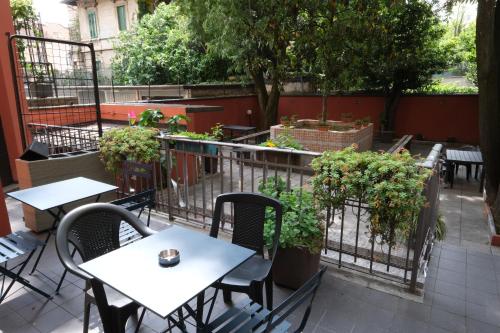 un patio al aire libre con mesas, sillas y plantas en Hotel 26, en Milán