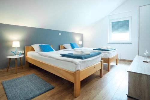 1 Schlafzimmer mit 2 Betten und blauen Kissen in der Unterkunft Apartment Roko in Slunj