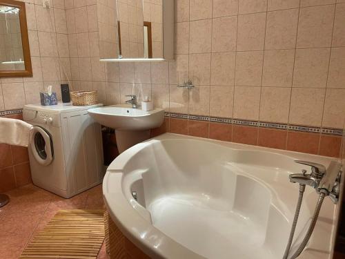 bagno con vasca bianca e lavandino di Kis-Celli apartman a Budapest