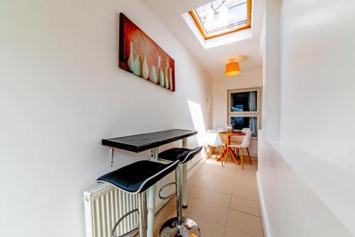 a hallway with a table and stools in a room at Stylish 3-bed Apartment with Free Parking and Wi-Fi in Chatham