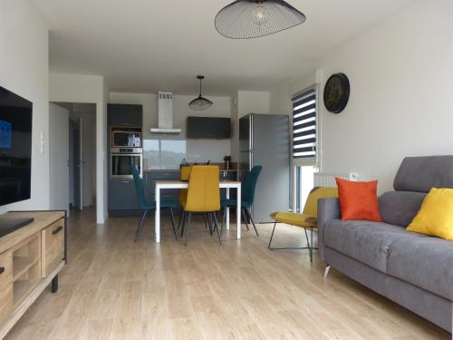 a living room with a couch and a table at Le colibri in Houlgate