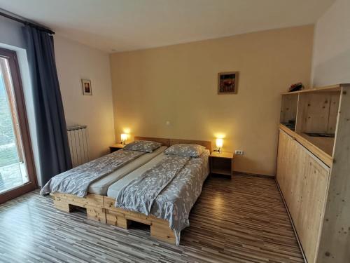 um quarto com uma cama, 2 candeeiros e uma janela em Apartment Rakušček em Kobarid