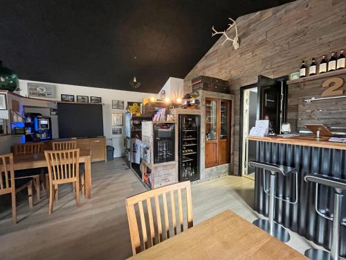 a kitchen with a bar and a dining room at Denmark Outdoor Lodge in Ebberup