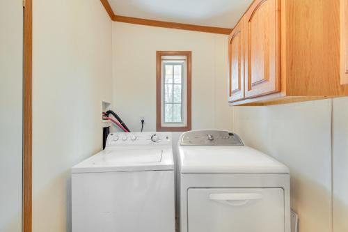 a small laundry room with a washer and dryer at Cozy Midcoast Vacation Rental Near Waterville! 