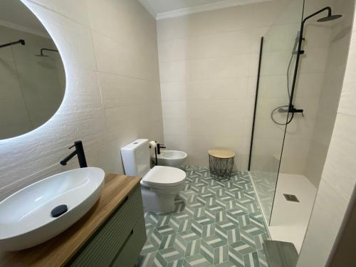 een badkamer met een wastafel, een toilet en een douche bij Apartamento flor de amendoeira in Albufeira
