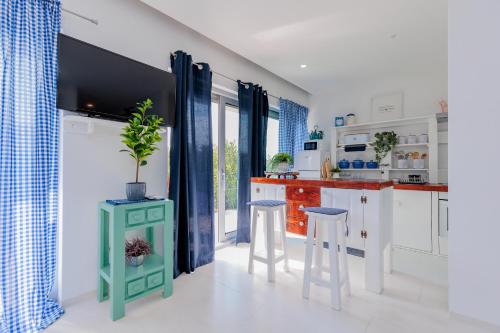- une cuisine avec des placards blancs et des rideaux bleus dans l'établissement Luxury Apartment Slavica by the sea,with garden, à Sukošan