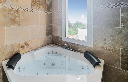 eine Badewanne im Bad mit Fenster in der Unterkunft Beautiful Home In Portiragnes With Kitchen in Portiragnes