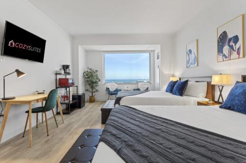 una camera d'albergo con 2 letti e una scrivania di Beachfront Double Queen - CozySuites ad Atlantic City