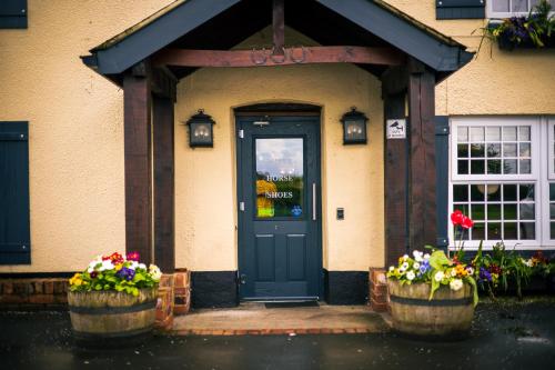 eine Haustür eines Hauses mit Blumen in Töpfen in der Unterkunft Three Horseshoes Inn in Durham