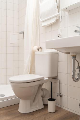 a white bathroom with a toilet and a sink at Air Apartment 104 in Vilnius