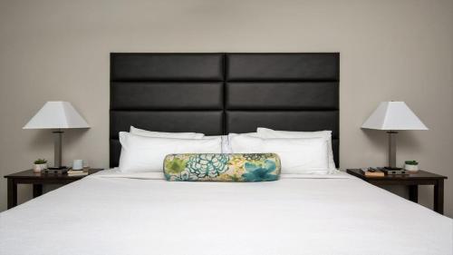 a large bed with a pillow on it with two lamps at Bold CozySuites with gym, roof #7 in Dallas