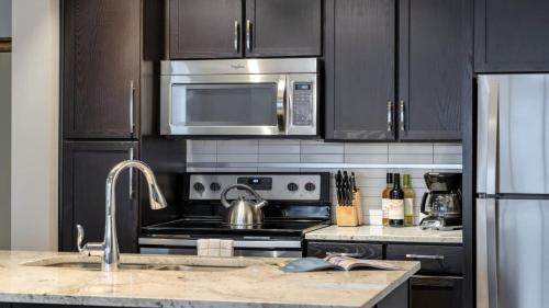 a kitchen with a stainless steel stove and microwave at Bold CozySuites with gym, roof #7 in Dallas