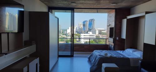 a bedroom with a bed and a view of a city at Edificio Flats del sol in Asunción