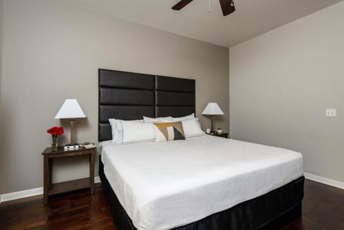 a bedroom with a large bed with a black headboard at Downtown Dallas CozySuites with roof pool, gym #4 in Dallas