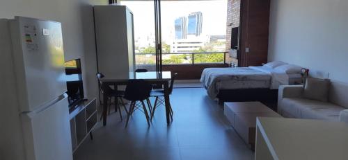 a small room with a bed and a table and chairs at Edificio Flats del sol in Asuncion