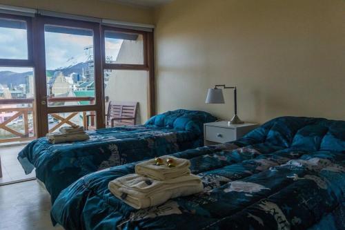 Duas camas num quarto com uma janela grande em Gente del Sur - Odino em Ushuaia