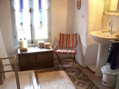 a bathroom with a chair and a sink and a window at Casa Rosalie in Borgomaro