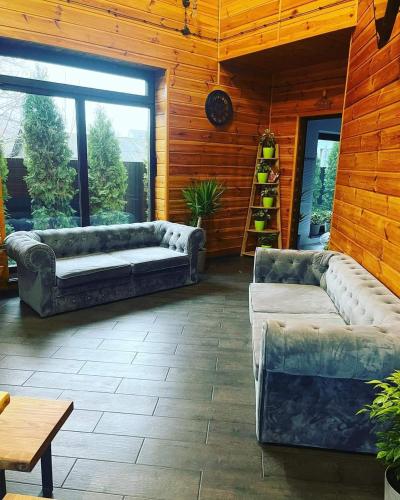 a living room with two couches and a table at Хвоя - комплекс відпочинку in Boryspilʼ