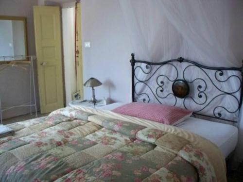 - une chambre dotée d'un lit avec un couvre-lit floral dans l'établissement Casa Rosalie, à Borgomaro