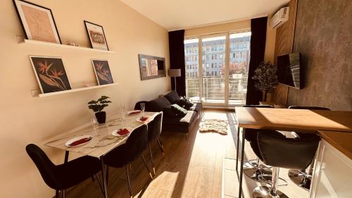een woonkamer met een tafel en stoelen in een kamer bij Green Stone Apartment II in Bydgoszcz