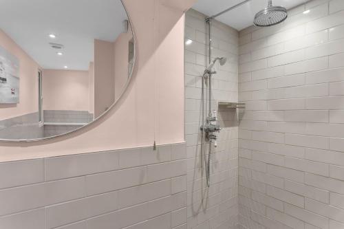 a bathroom with a shower and a mirror at The Admiralty Wash House in Dartmouth