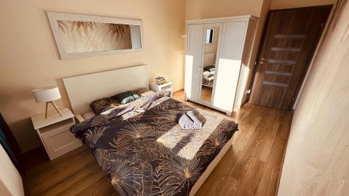 małą sypialnię z łóżkiem i lustrem w obiekcie Green Stone Apartment II w Bydgoszczy