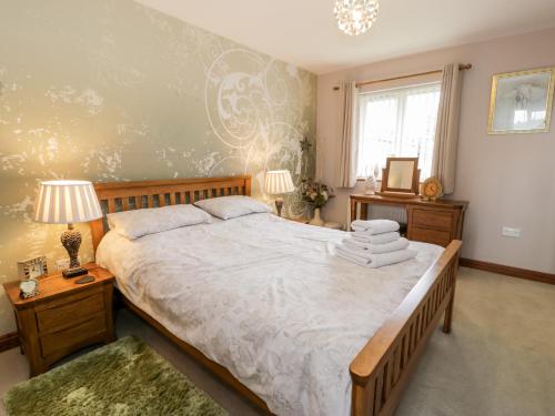 um quarto com uma cama grande e uma janela em 6 Stad Yr Ysgol em Blaenau-Ffestiniog