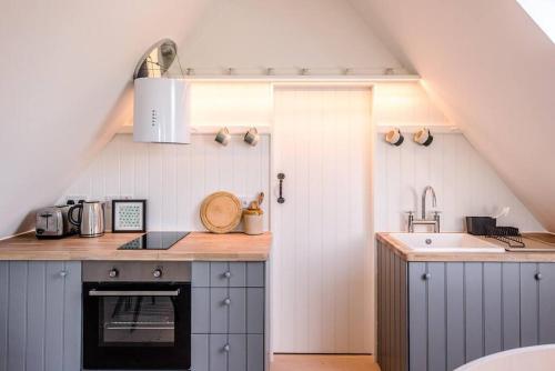 una cucina con lavandino e piano di lavoro di Yoxford Farm Hayloft a Saxmundham