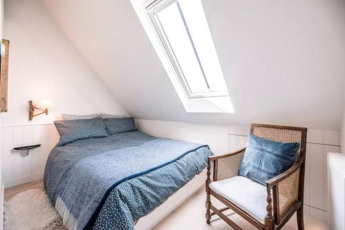 um quarto com uma cama e uma cadeira em Yoxford Farm Hayloft em Saxmundham