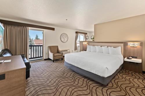 a hotel room with a bed and a balcony at Cedar Street Hotel & Suites in Sandpoint