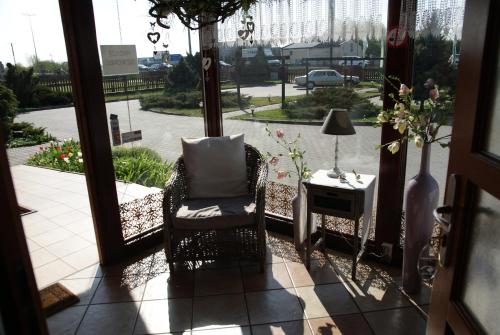 a porch with a chair and a table and a window at Willa Wiosna in Września