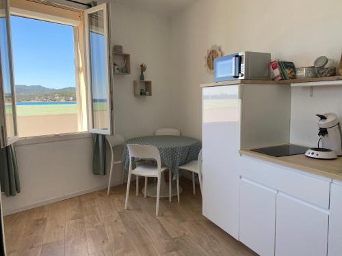 a small kitchen with a table and a window at Studio le Monroe les pieds dans l'eau 10 m de la mer in La Seyne-sur-Mer