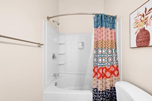 a bathroom with a tub and a shower curtain at City View - Downtown Walking Palace in Salt Lake City