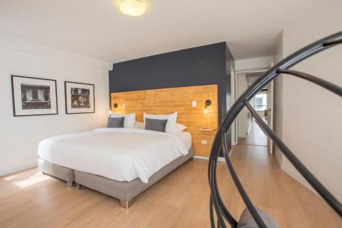 1 dormitorio con 1 cama blanca grande y pared negra en Nomad By Wynwood House, en Lima