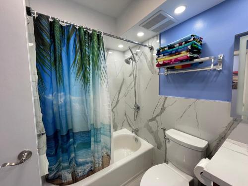 y baño con aseo y cortina de ducha. en Amazing waikiki Beach condo 2Bed2Bath+free Parking, en Honolulu