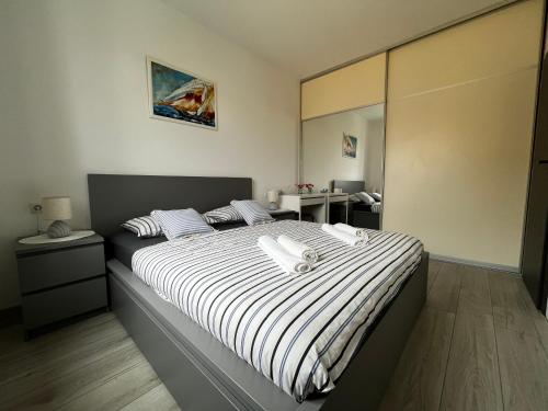 a bedroom with a bed with a black and white blanket at Apartman Valor in Rovinj
