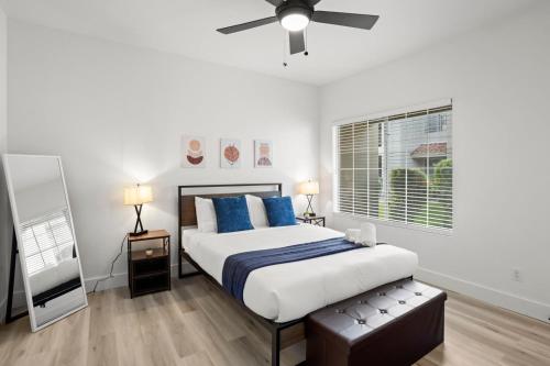 a bedroom with a bed with blue pillows and a ceiling fan at NEW CozySuites TPC Scottsdale with parking, pool in Scottsdale