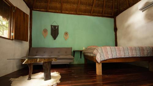 a living room with a couch and a table at Casa Tulix Cabaña Tulum in Francisco Uh May