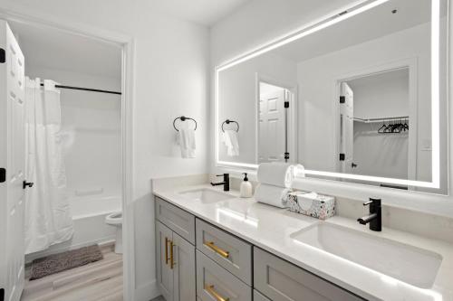 uma casa de banho branca com 2 lavatórios e um espelho grande em NEW CozySuites TPC Scottsdale with parking, pool em Scottsdale